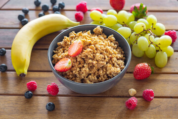 Bowl with homemade granola and various fruit ingredients for cooking tasty healthy food, wholesome...