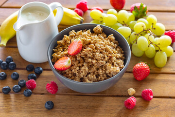 Bowl with homemade granola and various fruit ingredients for cooking tasty healthy food, wholesome...