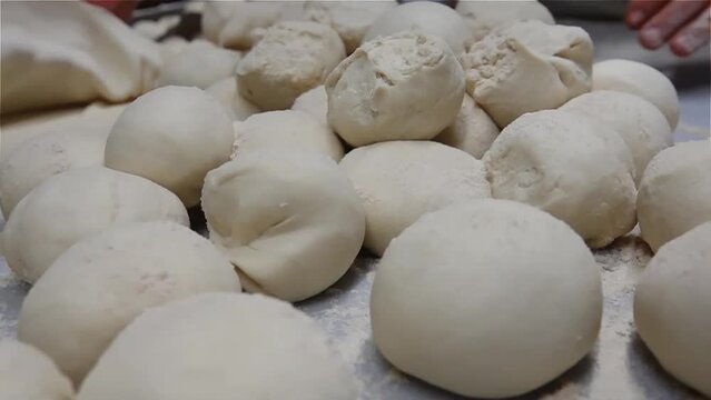 Making Lahmacun or Turkish pizza, pide dough by close up male hands in pastry kitchen, Chef preparing Turkish lahmacun