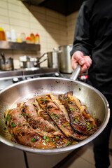 man chef cooking fried meat slice in frying pan on restaurant kitchen