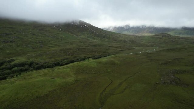 Vue a&eacute;rienne panoramique en drone de la montagne irlandaise surplomb&eacute;e de prairies et de nuages bas