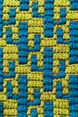 Blue crochet cactus background. Yellow blue crochet texture with mosaic crochet. Knitted background.