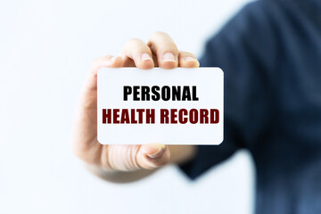 Personal health record text on blank business card being held by a woman's hand with blurred background. Business concept about health.