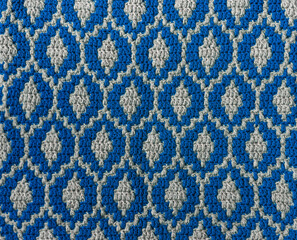 Blue white mosaic crochet texture. Drops shaped repeating pattern. Knitted background.