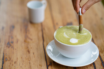 Hot green tea served with cinnamon on hand.