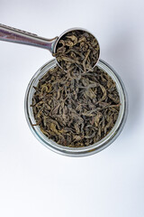 Herbata czarna wsypywana z łyżki do słoika