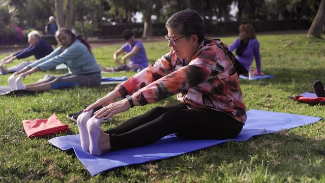 Senior sport people exercising during yoga workout class outdoor at park city - Fitness joyful Elderly lifestyle