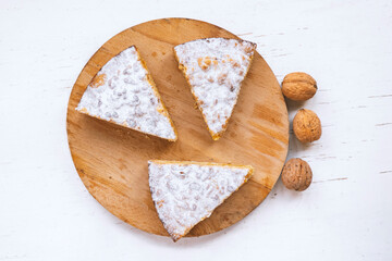 Sliced homemade apple and nuts cake on wooden background, top view