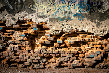Stara ceglana ściana z wypadającymi cegłami