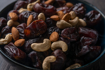 dates and nuts in a bowl on a dark background