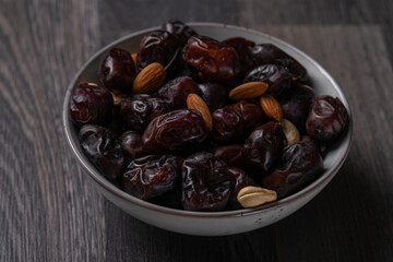 dates and nuts in a bowl on a dark background