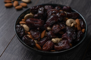 dates and nuts in a bowl on a dark background