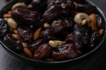 dates and nuts in a bowl on a dark background