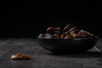 dates and nuts in a bowl on a dark background