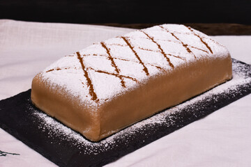 Tarta con capas de bizcocho y crema cubiertas de mazapán con azúcar glas por encima. Ponche segoviano, postre típico en Segovia, España. 