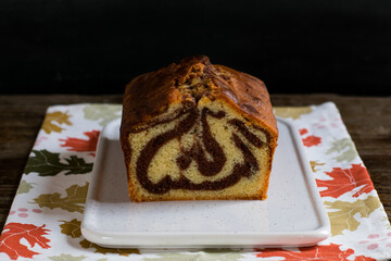 Bizcocho marmolado de vainilla y chocolate sobre tabla blanca de cerámica