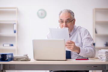 Old male employee working in the office