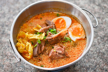curry bone soup pork bone soup with boiled eggs in hot pot, Thai food tom yum hot and sour soup