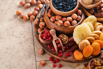 Tu Bishvat celebration concept. Mix of dry fruits and nuts almonds, hazelnuts, walnuts, apricots, prunes, cherries, raisins, dates, apples, figs over wooden table. Jewish holiday, new year of trees.