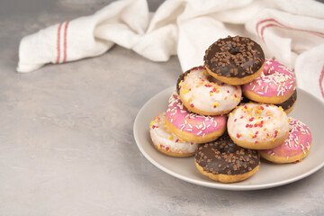 two donuts in a heartshape on a gray background on a white plate. Concept for Valentine's Day. Valentine's Day dessert. flatly space for text, copy space