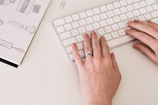 woman's hands on keyboard, with wedding ring