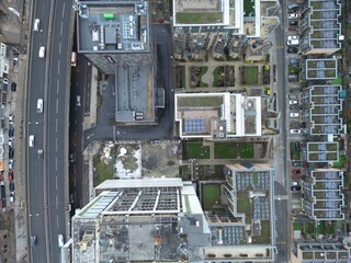 Looking down at the city below - vertical drone aerial shot of highways, roads and buildings