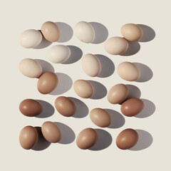 Easter eggs square pattern with gradient colored eggshell, hard Shadow at sunlight, beige background. Chicken eggs layout, top view, minimal flat lay, holiday food still life photo, trend