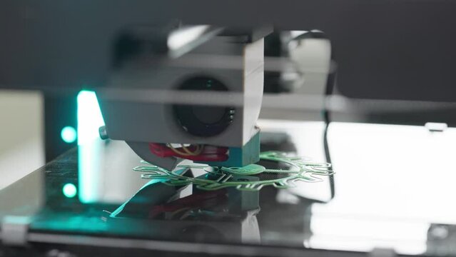 The 3d printer is printing a gear from green plastic. A layer by layer appears on the desktop new detail. concept of modern design technology