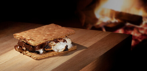 Less than perfect  S'more that is freshly homemade next to a campfire