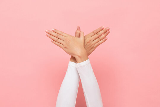 Bird hand gesture sign in isolated pink studio background