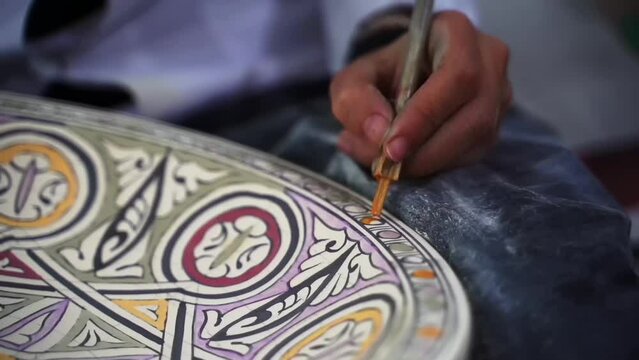 Morocco, woman working on art, hammer, pottery. Faz