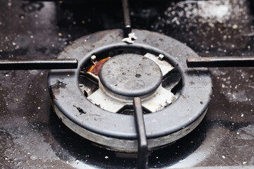 Dirty gas stove. Grunge kitchen oven. Cleaning service needed. Cooker background. Messy gas burner.