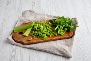 Raw Green Organic Celery on a rustic wooden board, side view.