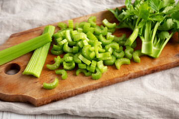 Raw Green Organic Celery on a rustic wooden board, low angle view.