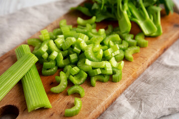 Raw Green Organic Celery on a rustic wooden board, side view.