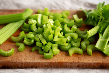 Raw Green Organic Celery on a rustic wooden board, side view. Close-up.