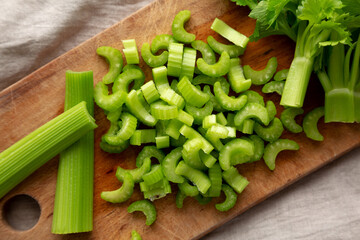 Raw Green Organic Celery on a rustic wooden board, top view.