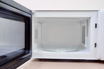 Clean white microwave oven with open door after washing and cleaning