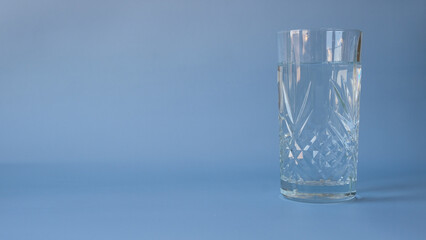 A glass of water on a blue background with a place for text