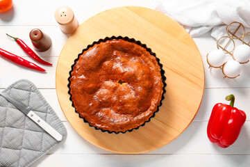 Composition with delicious meat pie, peppers and eggs on white wooden table