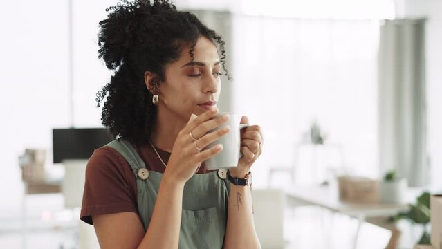 Coffee, thinking and woman at office feeling relax and calm in a startup space with hot drink. Contemplating, idea and thought of a mixed race female at an ecommerce company in the morning with tea