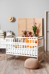 Interior of children's bedroom with baby crib and commode