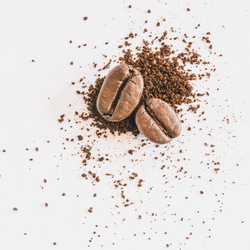 roasted coffee beans with ground coffee on white background © tendo23
