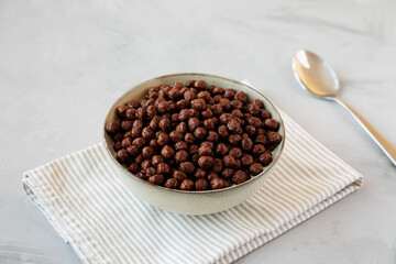 Chocolate Puff Cereal with Milk in a Bowl, side view.
