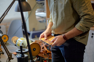 male's hands working with Leather Polishing Burnishing Machine Leather Edge Grinding Machine, croppes close up side view shot