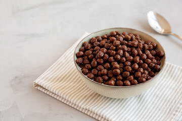 Chocolate Puff Cereal with Milk in a Bowl, side view. Copy space.