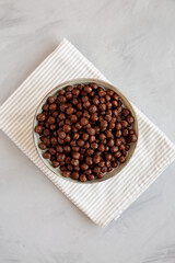 Chocolate Puff Cereal with Milk in a Bowl, top view. Flat lay, overhead, from above.