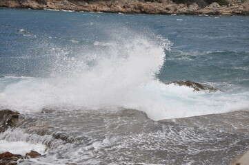 Wave breaking on the beach.Breaking sea wave on the rocky coast.The sea wave crashing on the rock and make the splashing water and white air foam bubble. Wave breaking on the beach.