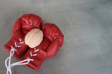 Human brain model on top of boxing gloves with copy space. Fight brain diseases concept