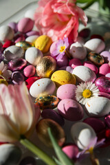 Mix of white, pink, yellow chocolate and foiled eggs and spring flowers.